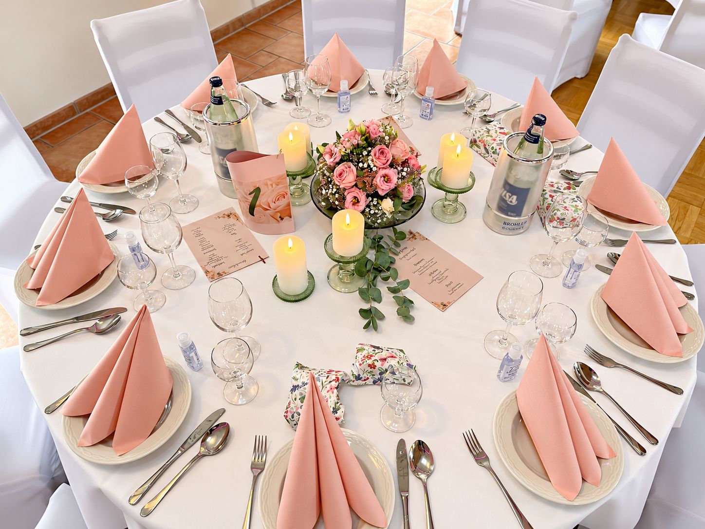Runder Tisch mit rosé Servietten und Blumengesteck