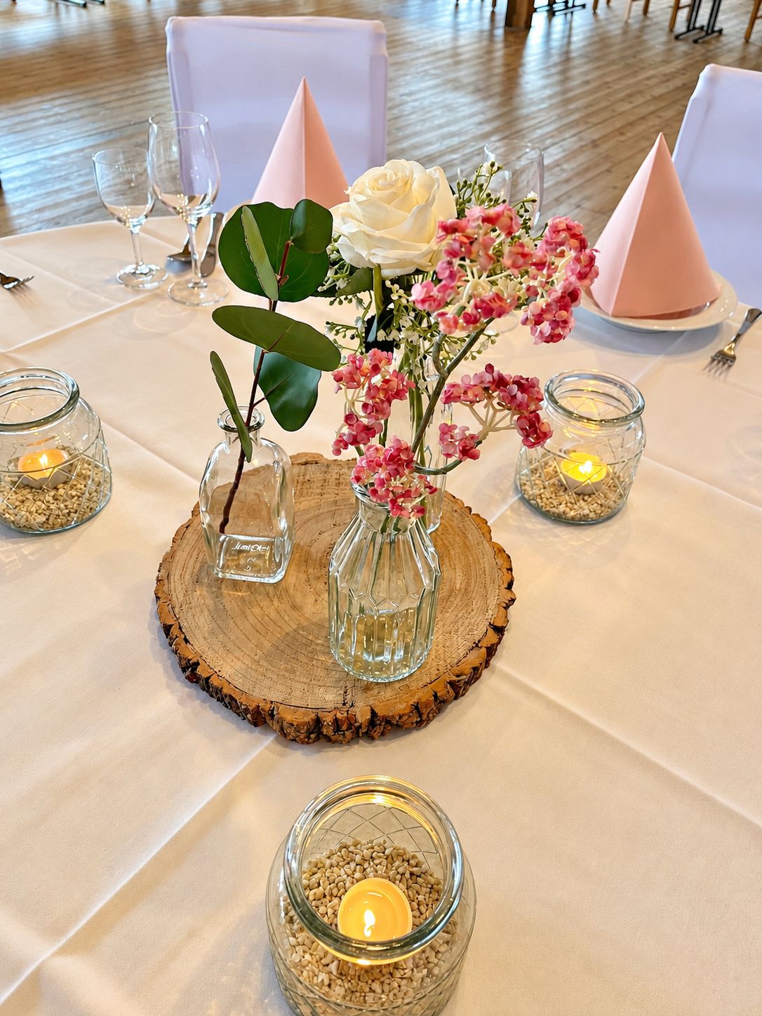 Tischdeko mit Holzscheibe, Blumen und Windlichtern